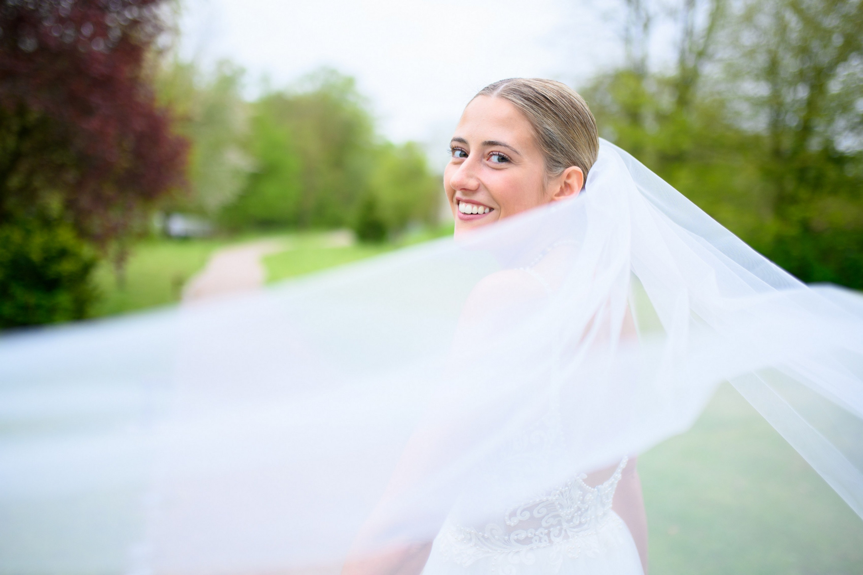 Brautportrait mit wehendem Schleier im Park — Holger Martens