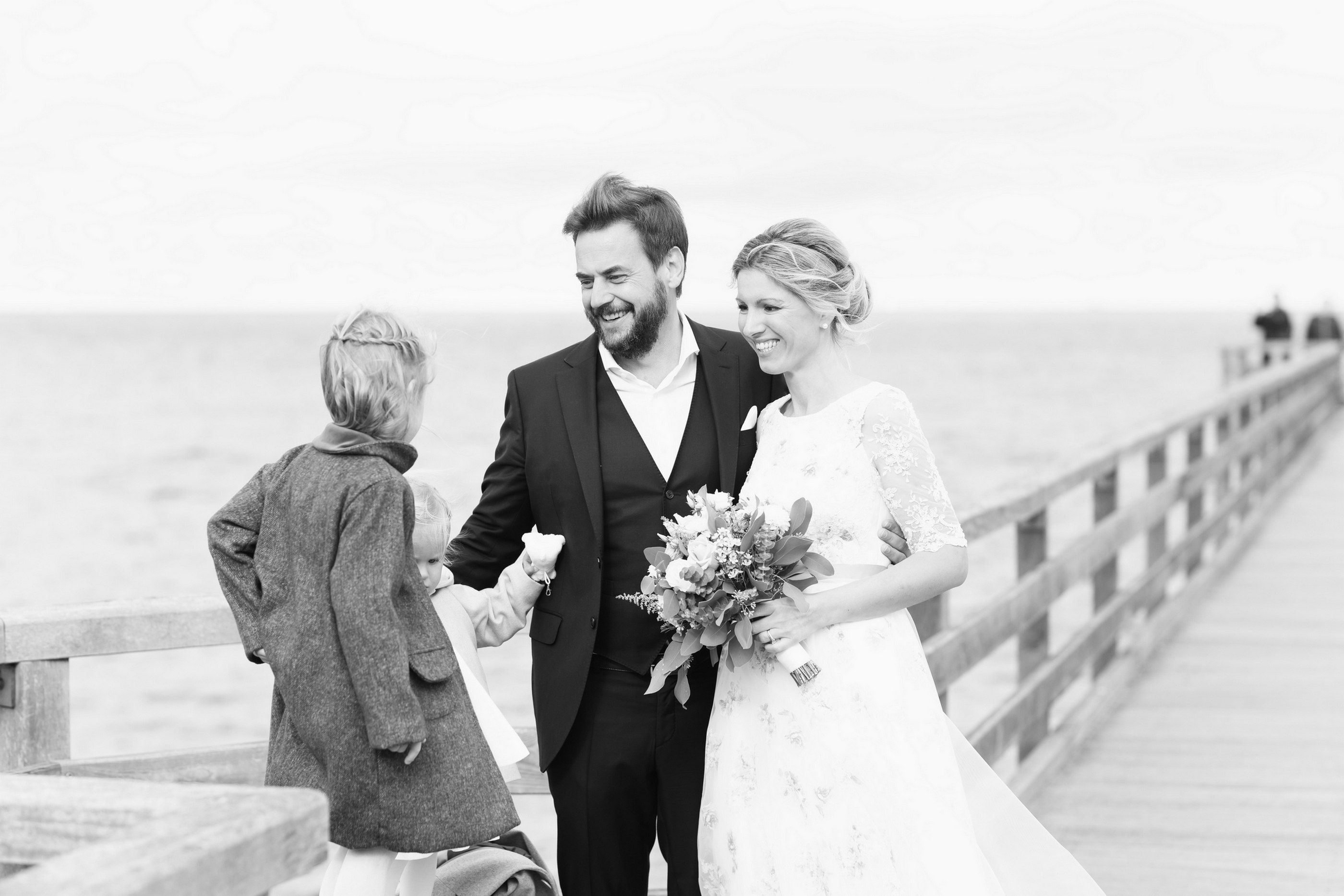 Hochzeitsgesellschaft auf Holzsteg am Meer, Schwarz-Weiß — Holger Martens