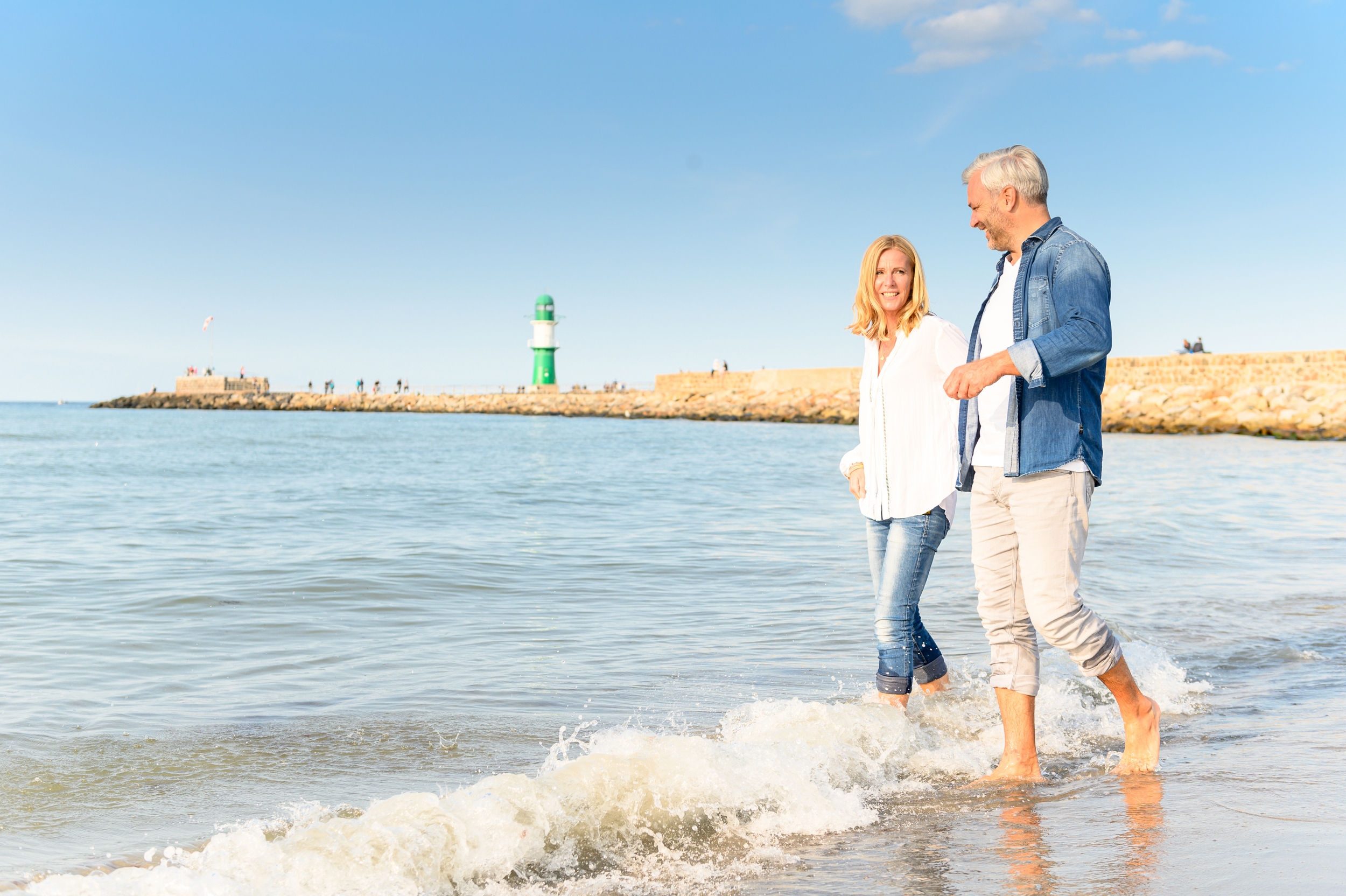 Kampagnenfotografie: Paar am Strand vor dem Leuchtturm Warnemünde