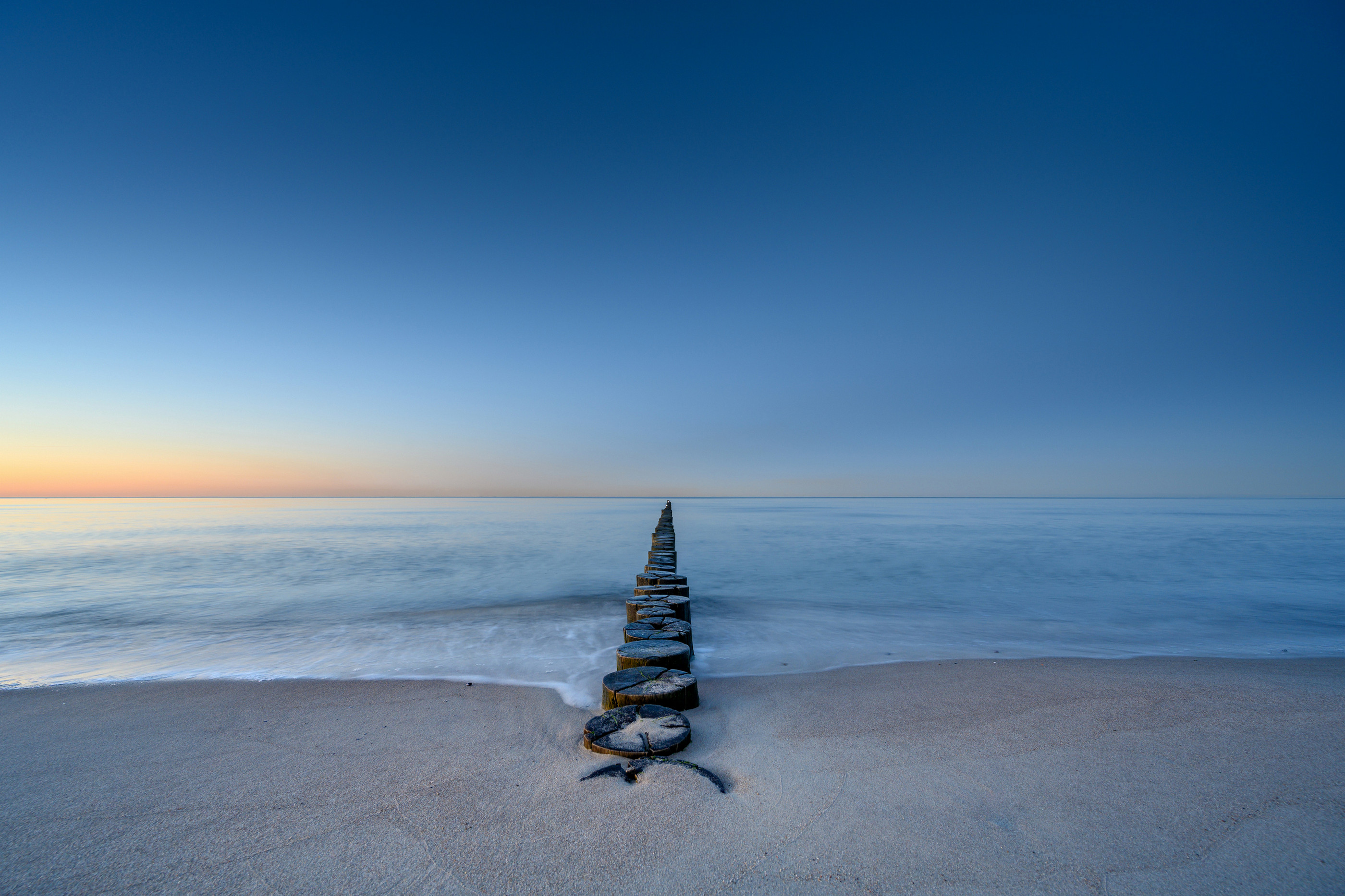 Landschaftsfotografie: Ostsee-Strand mit Buhnen im Sonnenaufgang