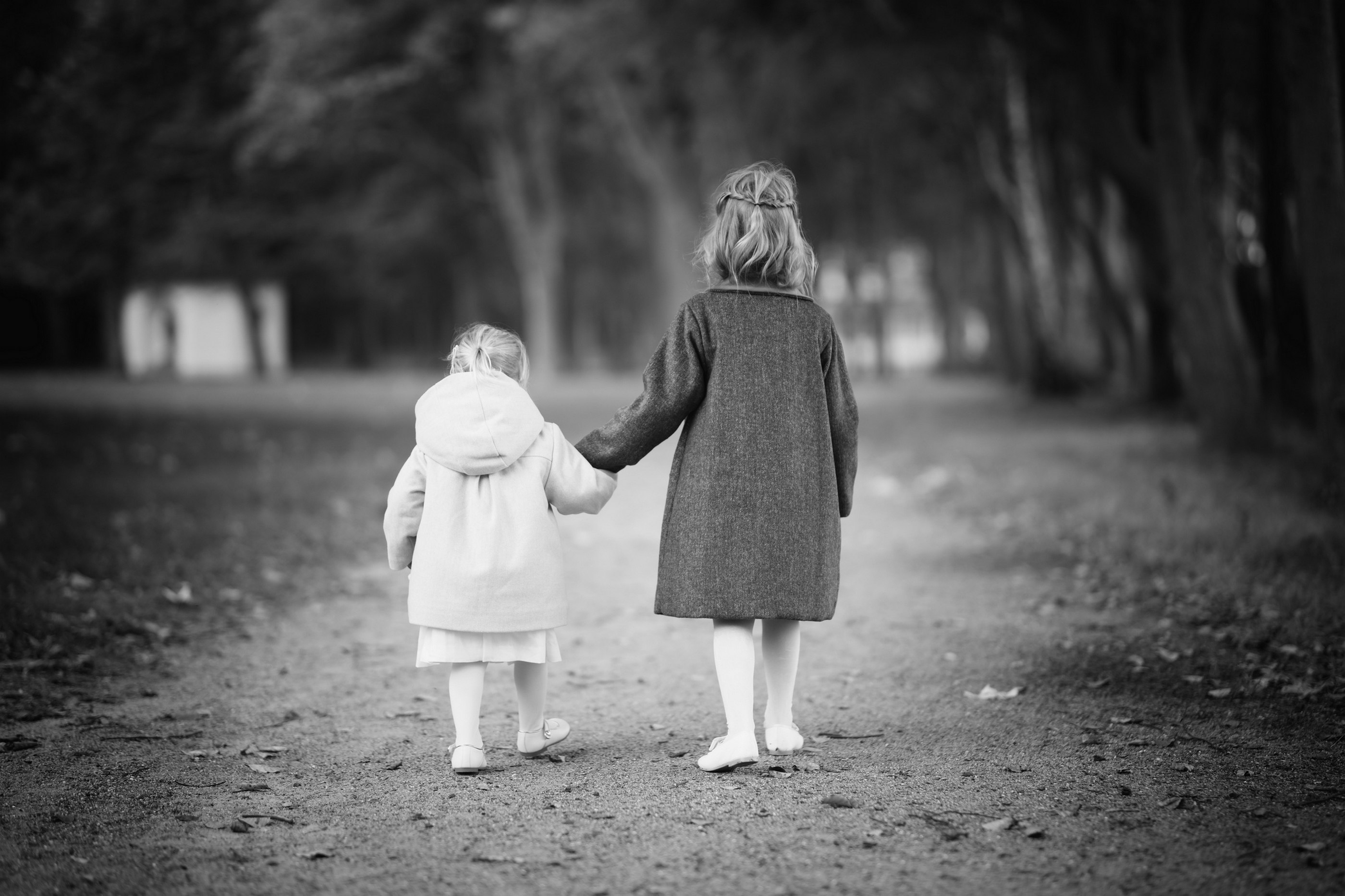 Zwei Schwestern Hand in Hand auf Waldweg, Schwarz-Weiß — Holger Martens